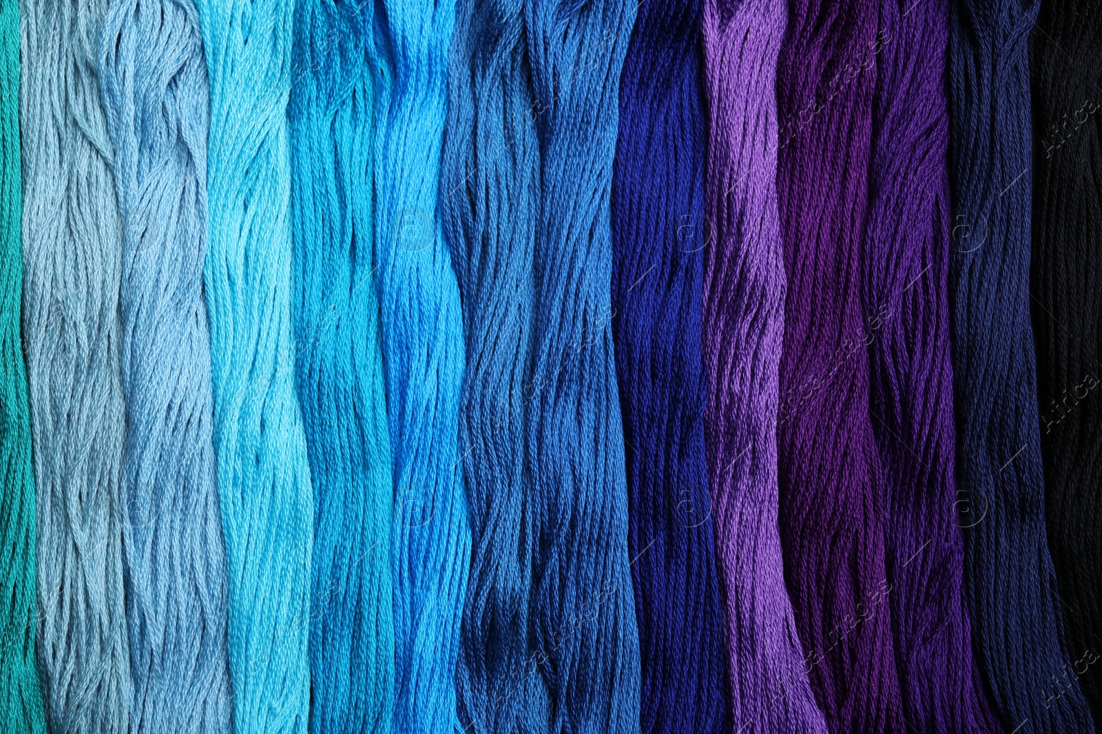 Photo of Different colorful embroidery threads as background, top view