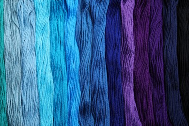 Photo of Different colorful embroidery threads as background, top view