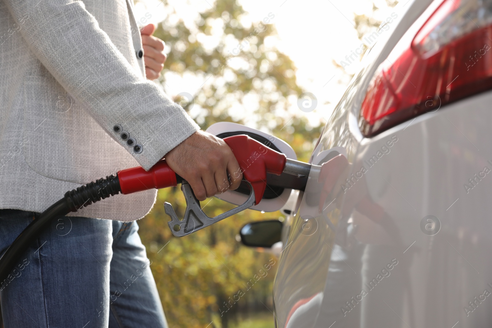 Photo of Man refueling car at self service gas station, closeup