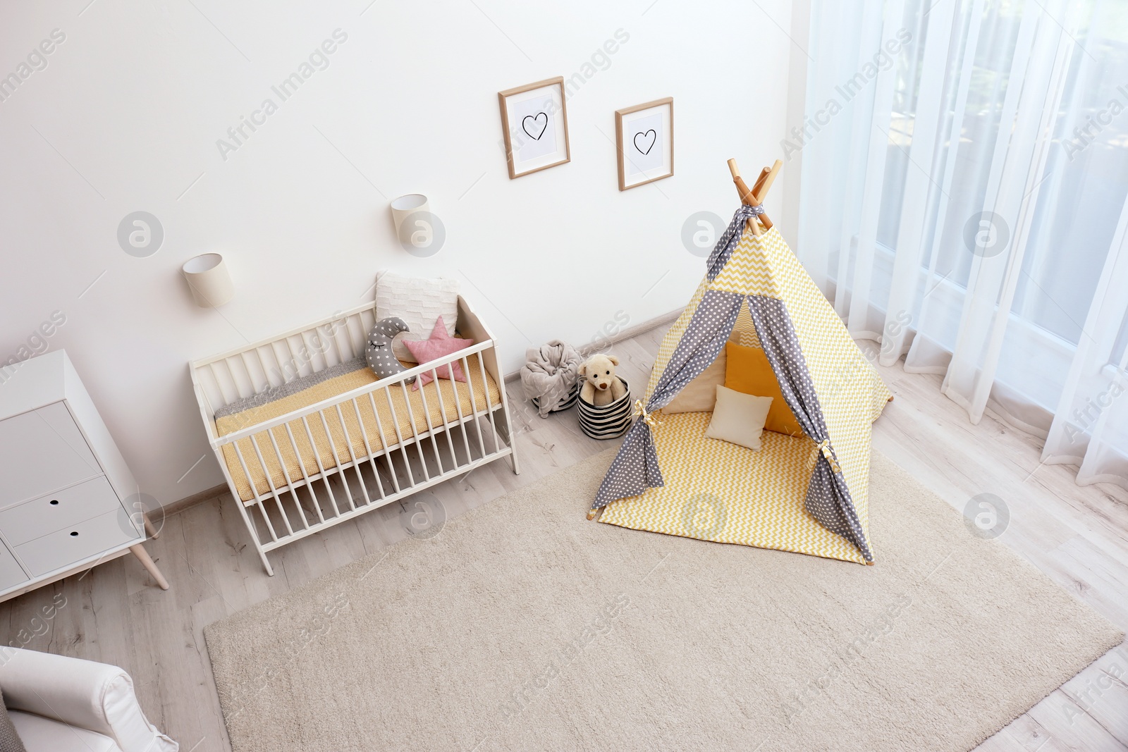 Photo of Cozy baby room interior with play tent and toys, above view