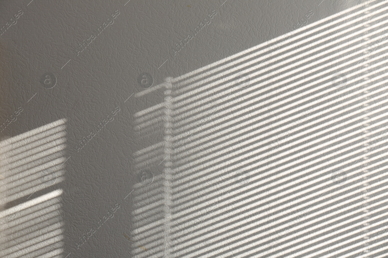 Photo of Light and shadow from window on white wall, space for text