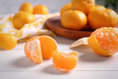 Photo of Fresh tangerines on white wooden table. Citrus fruit