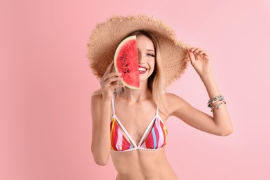 Pretty young woman with juicy watermelon on color background