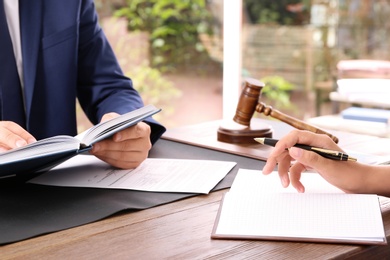 Photo of Lawyer working with client at table in office, focus on hands