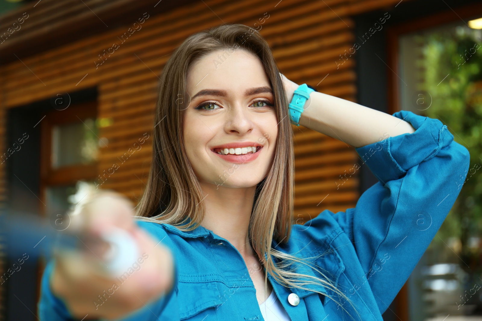 Photo of Happy young woman taking selfie on city street