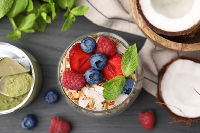 Photo of Tasty oatmeal with berries and mint on black wooden table, flat lay. Healthy breakfast