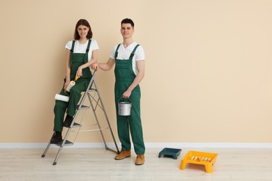Photo of Young workers with painting tools indoors, space for text. Room renovation