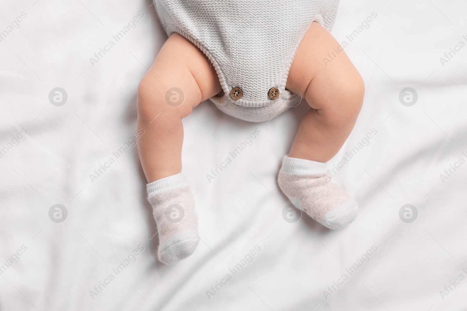 Photo of Newborn baby lying on white blanket, top view