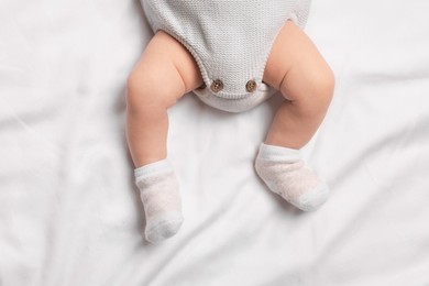 Photo of Newborn baby lying on white blanket, top view