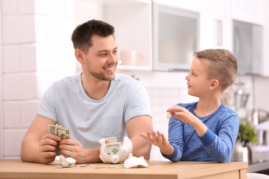 Photo of Family with broken piggy bank and money at home