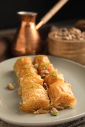 Photo of Delicious baklava with pistachio nuts on table, closeup