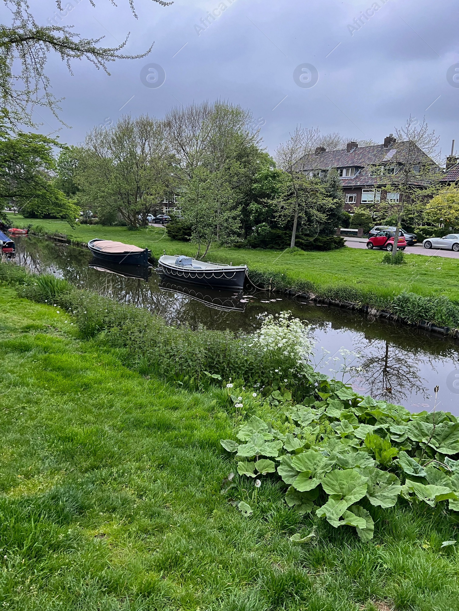 Photo of Canal with moored boats outdoors on cloudy day