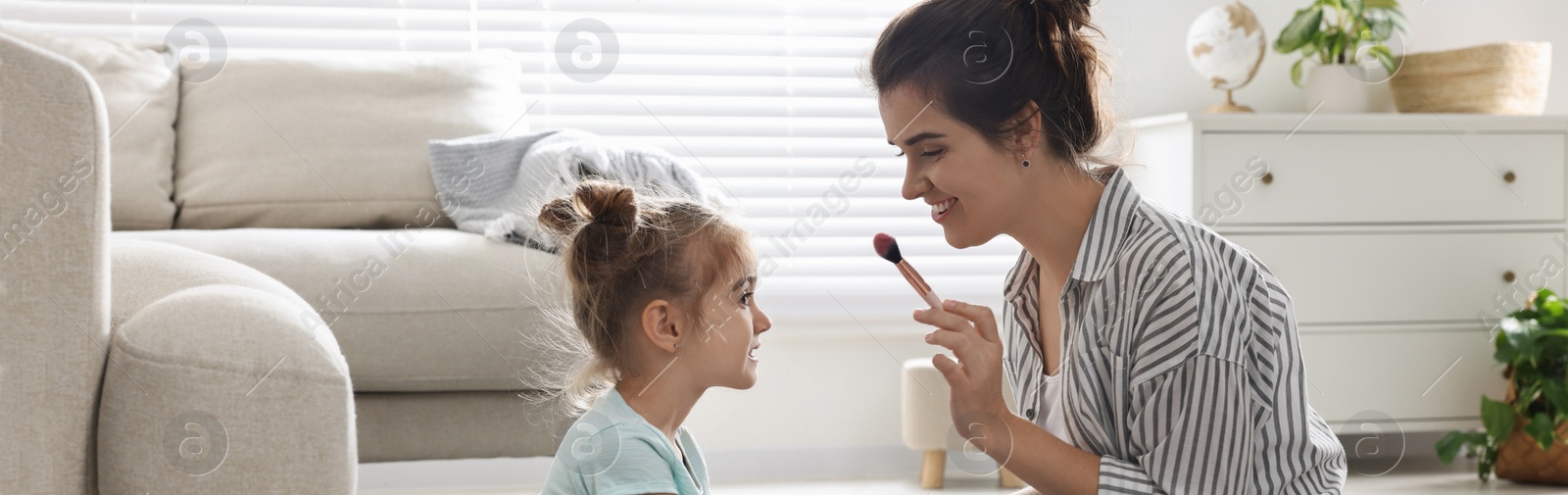 Image of Mother and her little daughter doing makeup at home, banner design