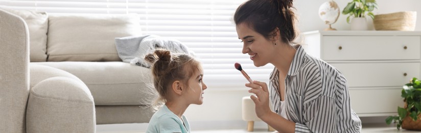 Mother and her little daughter doing makeup at home, banner design