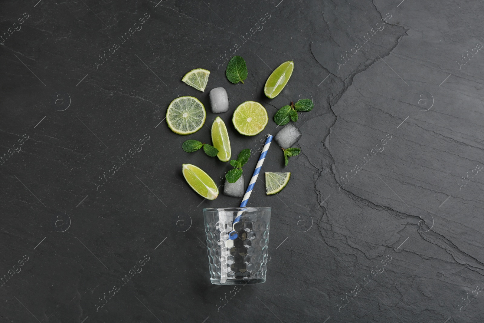 Photo of Creative lemonade layout with lemon slices, ice and mint on black table, top view