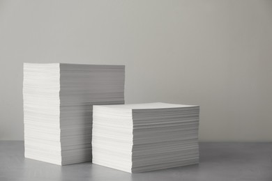 Photo of Stacks of paper sheets on grey table