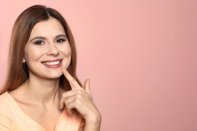 Smiling woman with perfect teeth on color background. Space for text