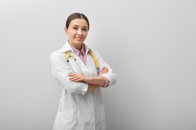 Photo of Pediatrician with stethoscope on light grey background, space for text