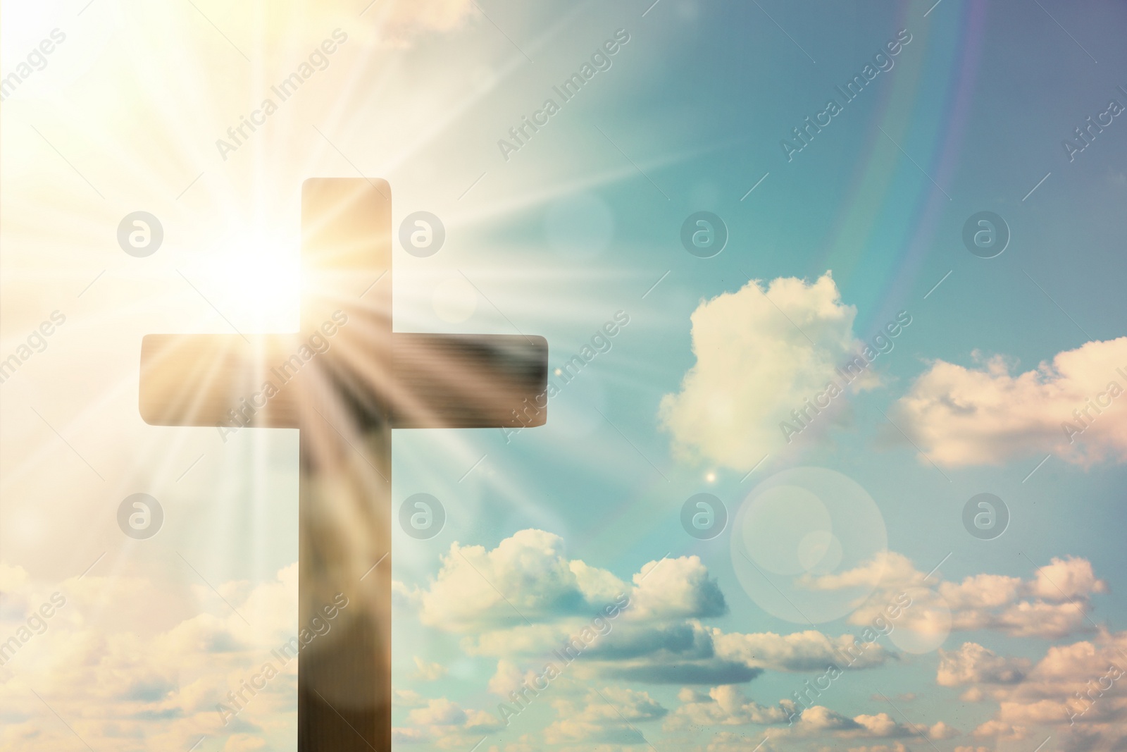 Image of Silhouette of cross against blue sky on sunny day. Christian religion