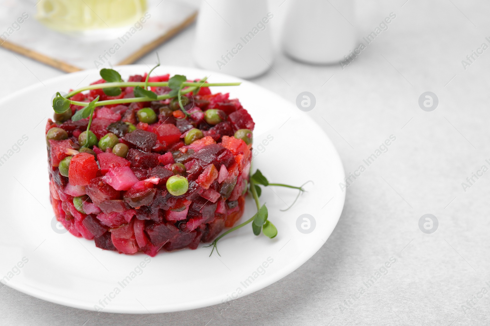 Photo of Delicious vinaigrette salad on light grey table, closeup. Space for text