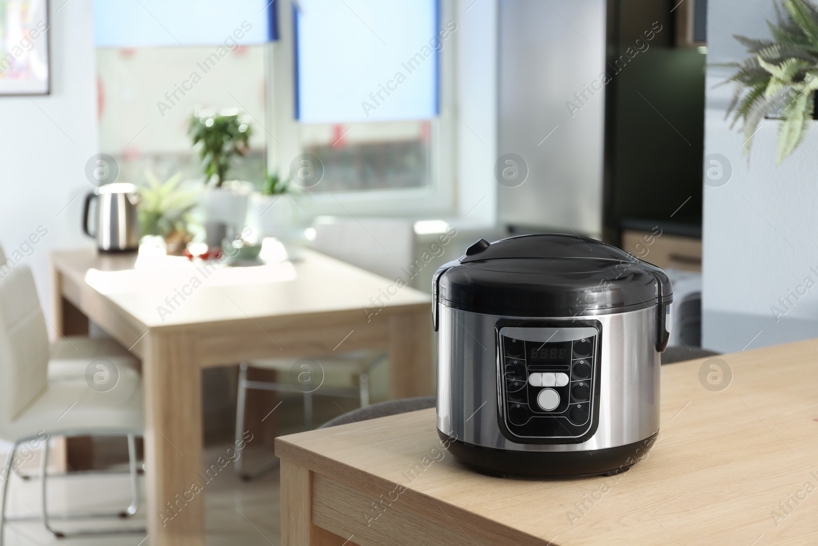 Photo of Modern multi cooker on table in kitchen. Space for text