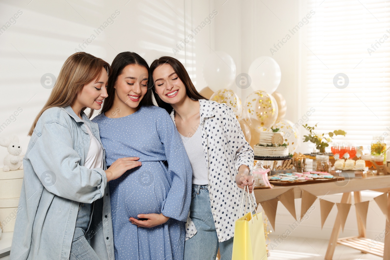 Photo of Happy pregnant woman spending time with friends at baby shower party