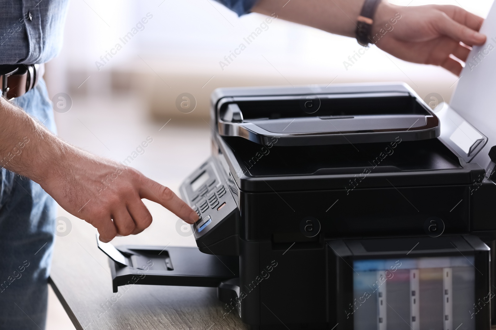 Photo of Employee using modern printer in office, closeup