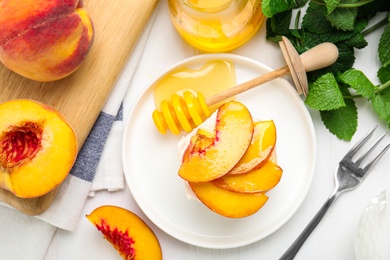 Delicious peach dessert on white wooden table, flat lay
