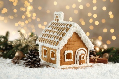 Photo of Beautiful gingerbread house decorated with icing on snow