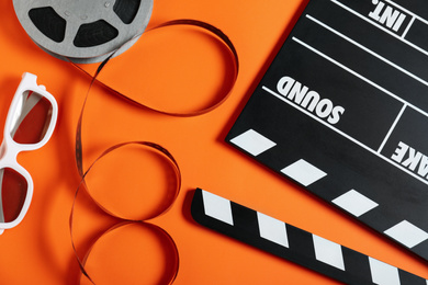 Flat lay composition with clapperboard on orange background. Cinema production