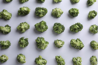 Many fresh green broccoli pieces on white background, flat lay