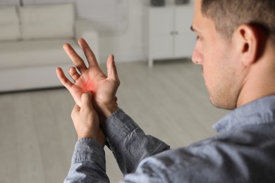 Image of Man suffering from trigger finger indoors, closeup