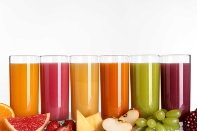 Photo of Glasses with different juices and fresh fruits on white background