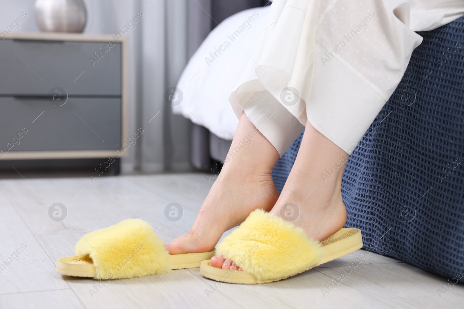 Photo of Woman in yellow soft slippers at home, closeup