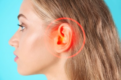 Image of Young woman with hearing problem on turquoise background, closeup