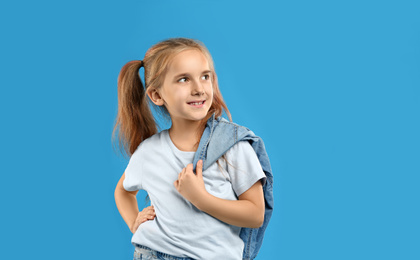 Photo of Cute little girl posing on blue background