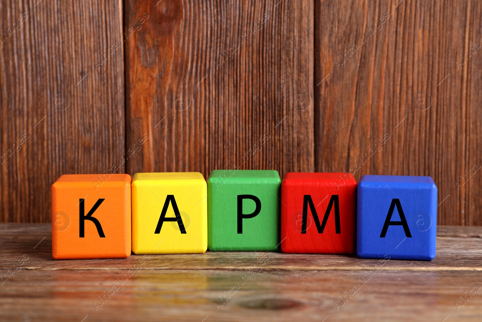 Photo of Word Karma made of colorful cubes with letters on wooden table