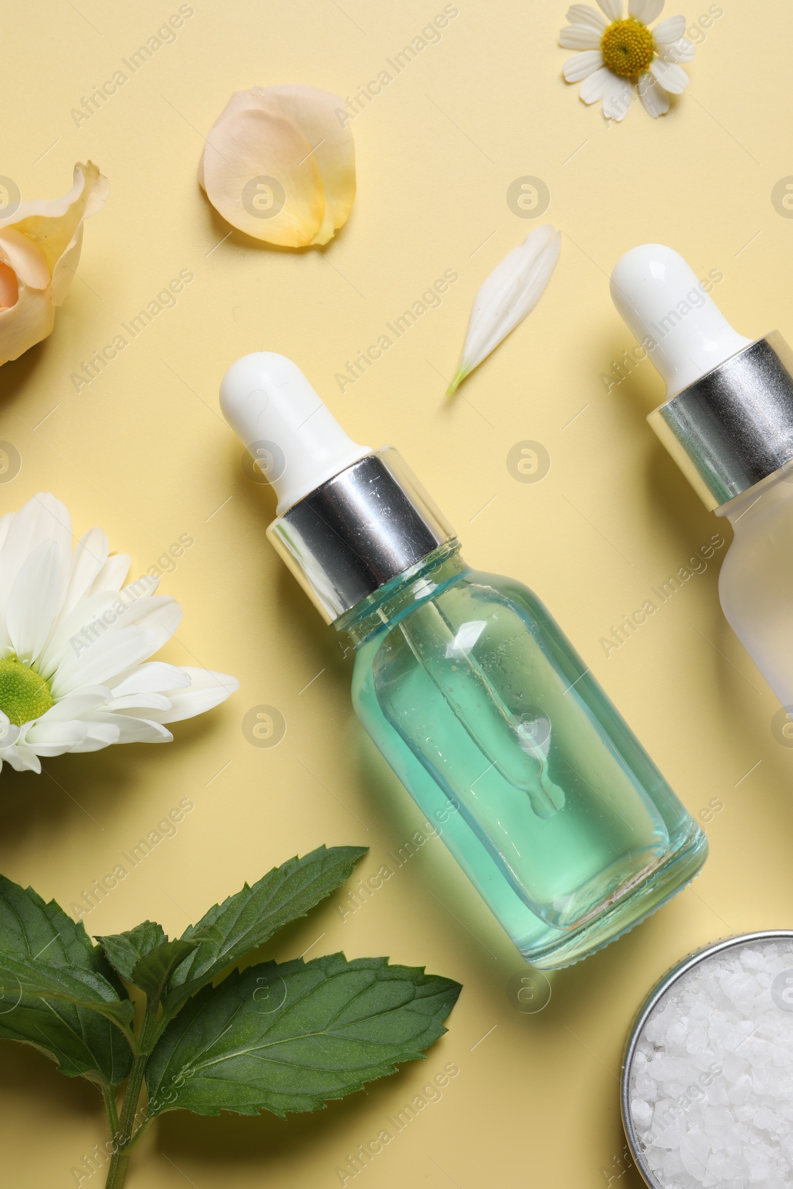 Photo of Flat lay composition with cosmetic serum on pale yellow background