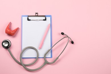 Photo of Endocrinology. Stethoscope, clipboard, model of thyroid gland and pen on pink background, flat lay. Space for text