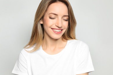 Photo of Portrait of young woman with beautiful face on grey background