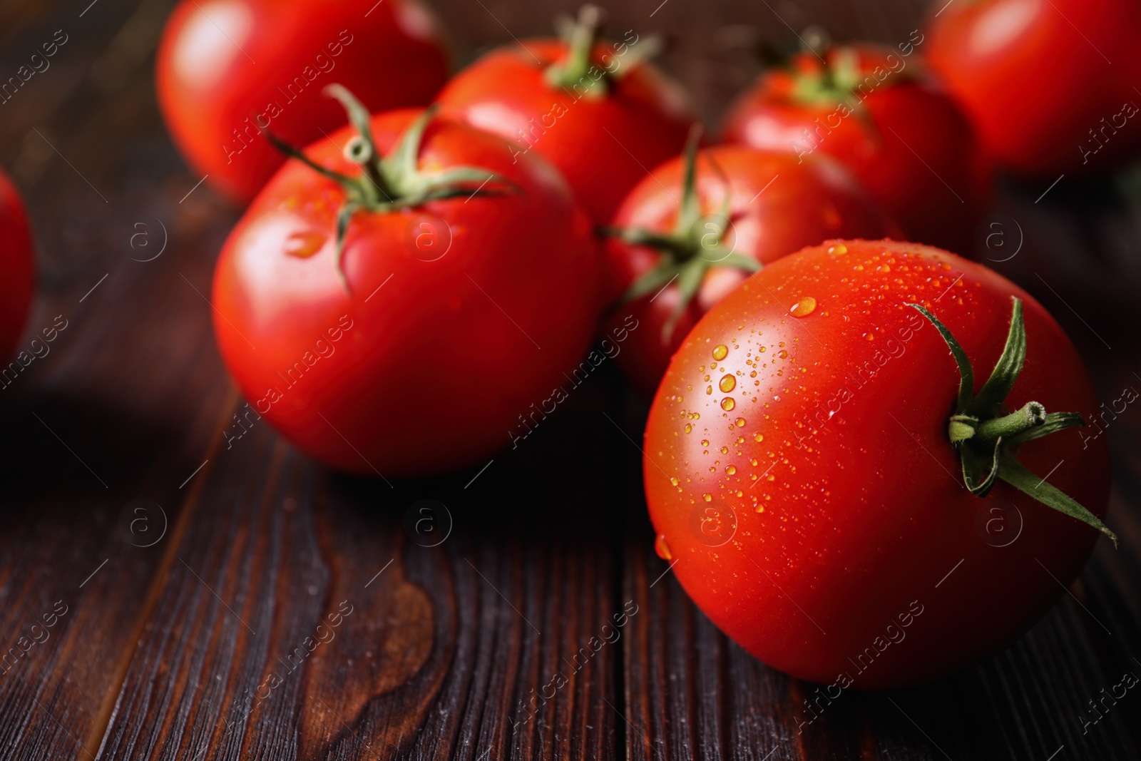 Photo of Fresh ripe tomatoes on wooden table, closeup