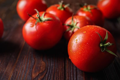 Fresh ripe tomatoes on wooden table, closeup