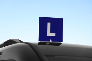 Photo of L-plate on car roof outdoors. Driving school