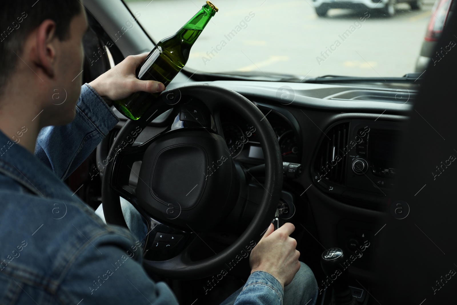 Photo of Man with bottle of beer driving car, closeup. Don't drink and drive concept