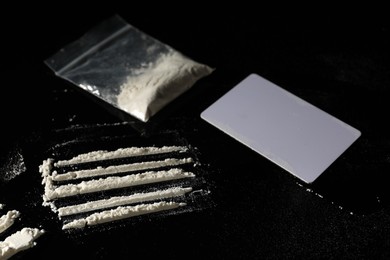 Photo of Drug addiction. Cocaine and blank card on black table