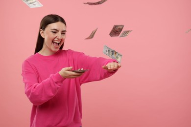 Photo of Happy woman throwing money on pink background, space for text