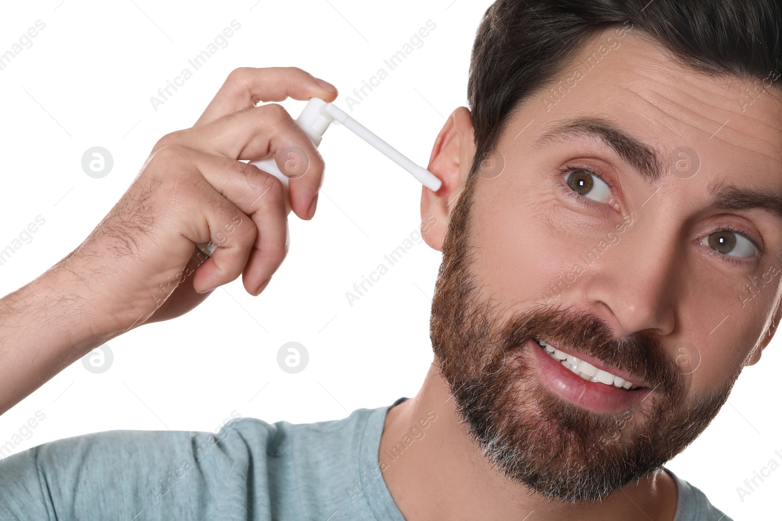 Photo of Man using ear spray isolated on white, closeup