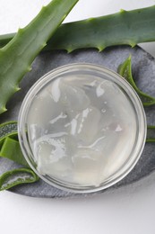 Photo of Aloe vera gel and slices of plant on white background, top view