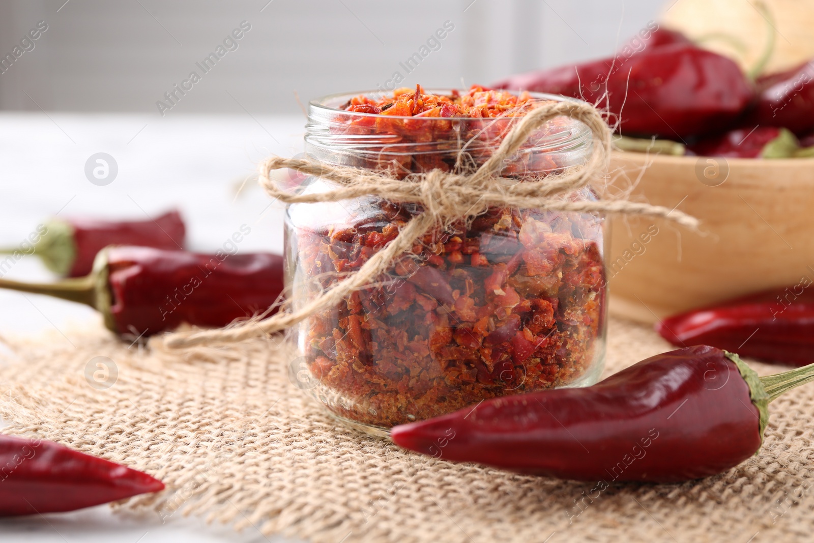 Photo of Chili pepper flakes and pods on table, closeup