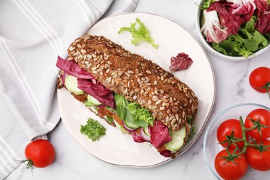 Photo of Delicious sandwich with schnitzel and ingredients on white marble table, flat lay